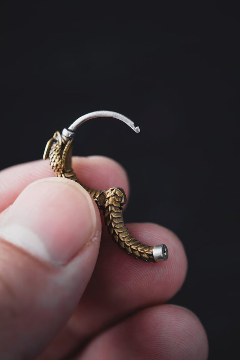 woman holding a gold earring
